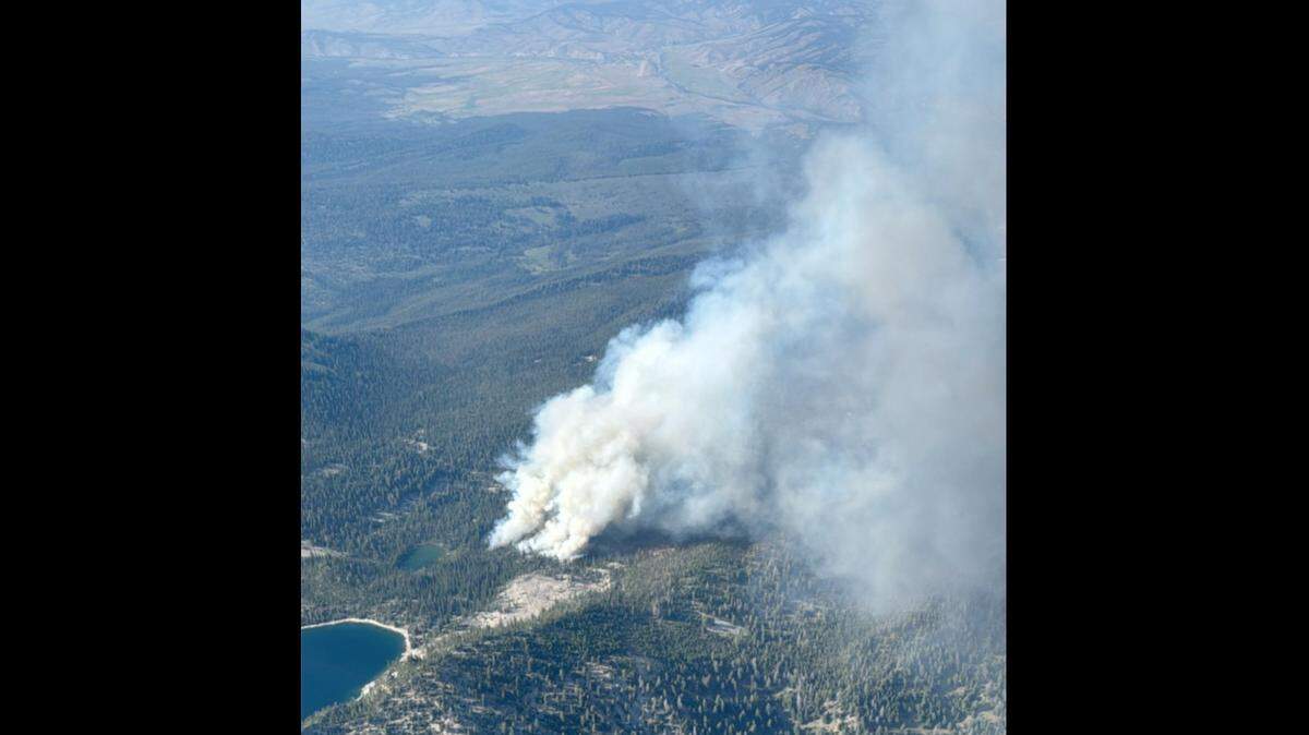 An aerial photo shared to Facebook by the Sawtooth National Forest shows a plume of smoke coming from a 40-acre wildfire called the Bench Lake Fire, a short distance from Redfish Lake.