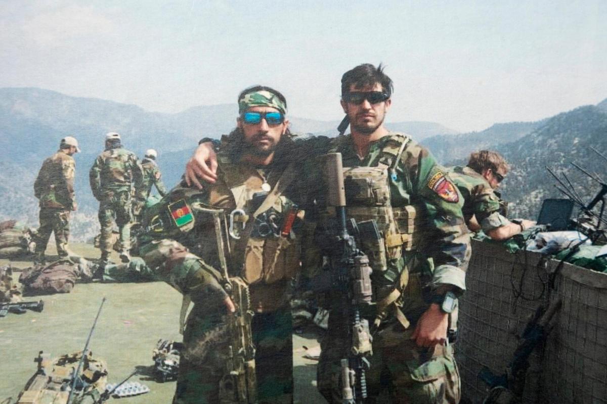 Akhtar Gul Silab, left, poses for a photo with an American military member in 2017 in Afghanistan.