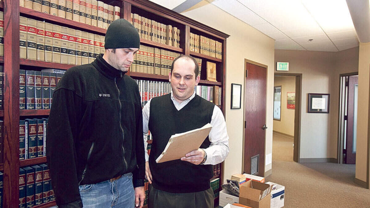Attorney Oscar S. Klaas and his client Doug Ackley look through documents at Brady Law office in Boise. Ackley sued a debt buyer in federal court after a botched attempt to collect from him. Klaas represented him in court.