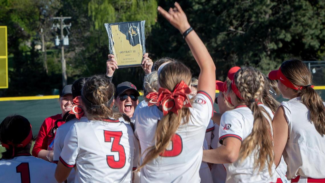 Owyhee softball coach Tess Martin holds up the 5A District Three softball championship plaque after the Storm defeated Eagle 7-5 for the title Friday at Borah High.