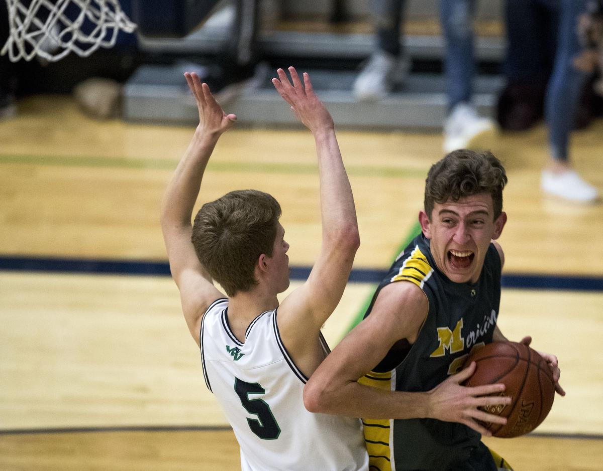 Meridian’s Jordan Pearce makes a baseline move to basket around Mountain View’s Austin Smart last season at Mountain View.