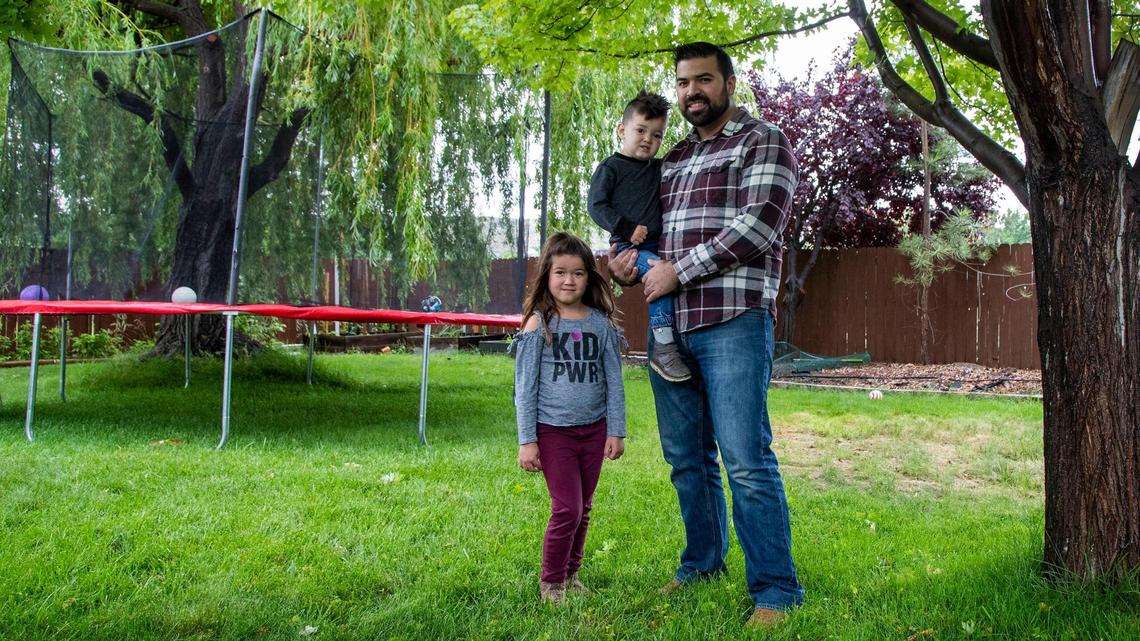 Jordan Morales holds his son Rico, 2, with daughter Amira, 5, in their Columbia Village backyard. He’s all for housing projects that will improve the community and provide a better life for people.