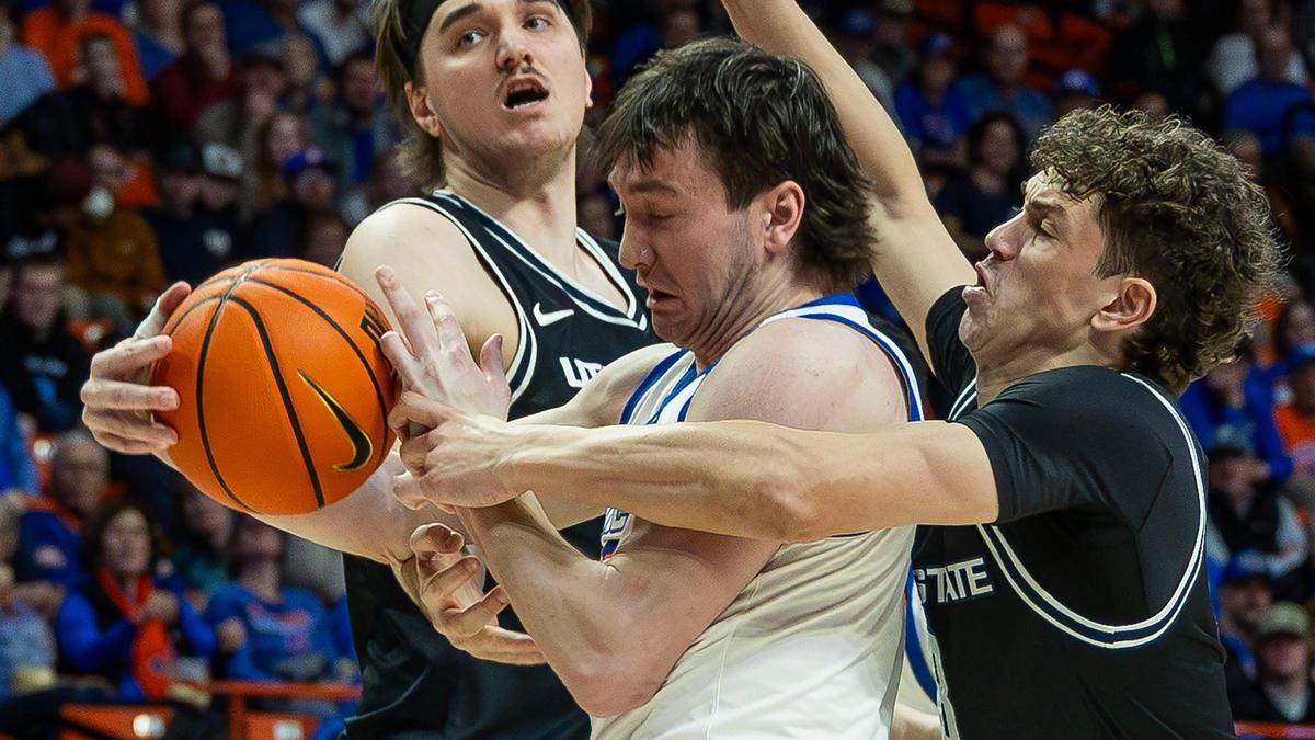Boise State forward RJ Keene II fights for control of a loose ball against a pair of Utah State players in a game last February.