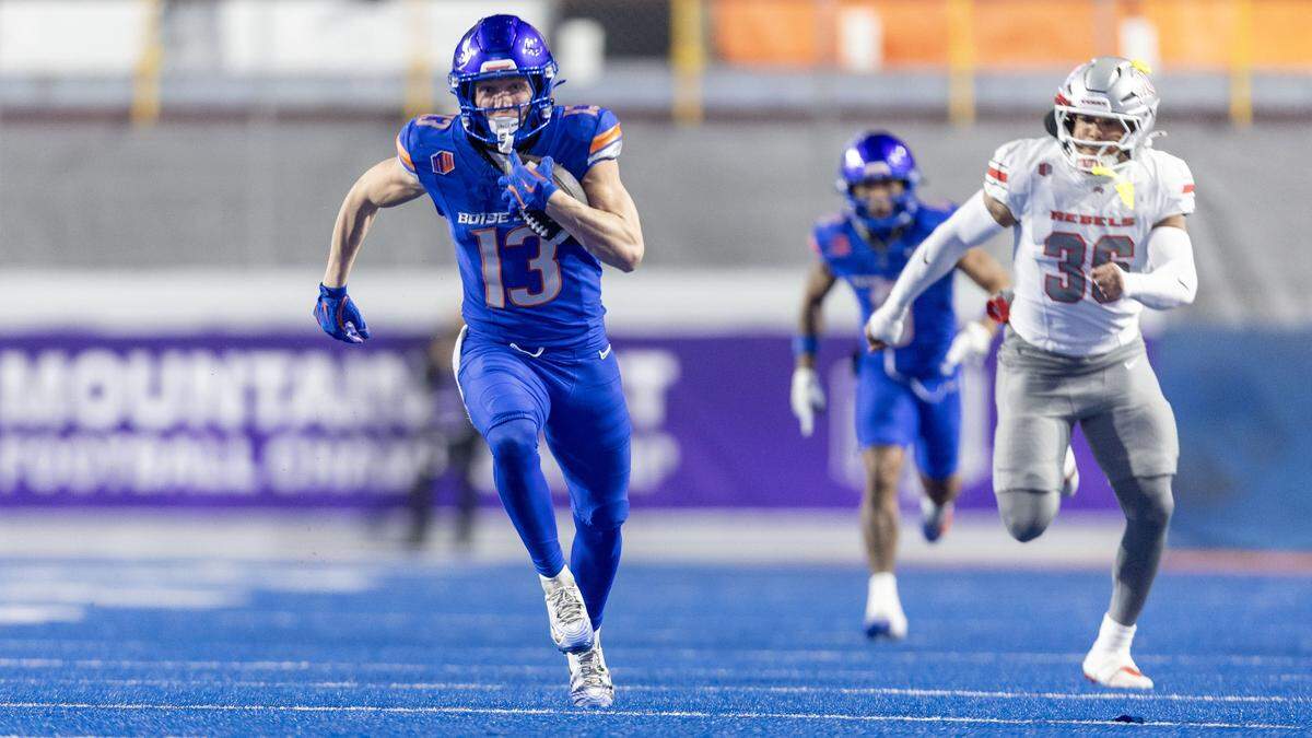 Boise State wide receiver Chase Penry runs for a big gain after a pass reception chased by UNLV linebacker Justin Flowe in the Mountain West championship game at Albertsons Stadium in Boise, Friday, Dec. 5, 2025.