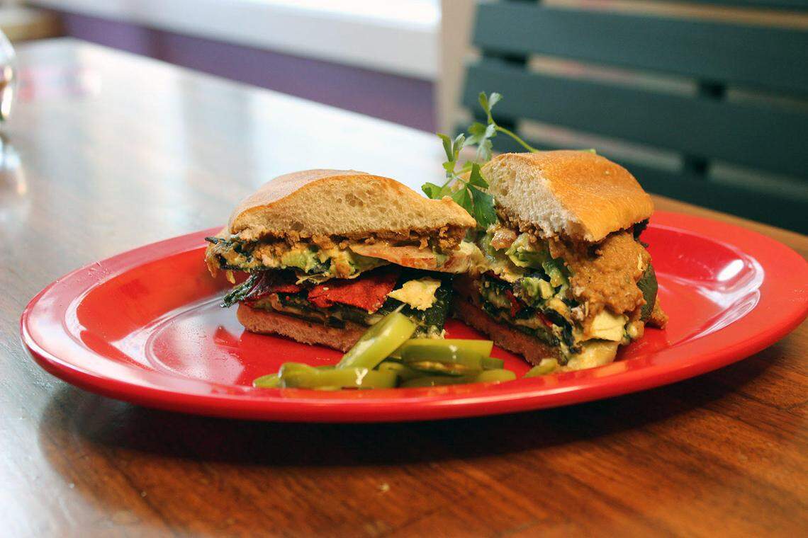 The Roasted Poblano Torta ($11) includes fire-roasted poblano peppers stuffed with Oaxaca cheese, spiced pinto bean puree, tortilla chips, tomatoes, cilantro lime aioli and avocado.
