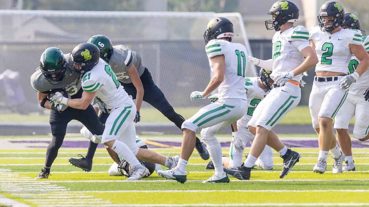 Eagle running back Noah Burnham is pushed out of bounds by West Linn safety Shane Peters on Saturday.