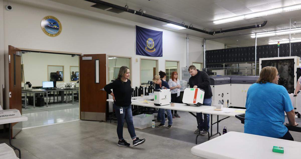 Poll workers remove each voting machine’s V-drive by breaking a seal, then bring the drives into the tabulation room, left, to calculate election results.