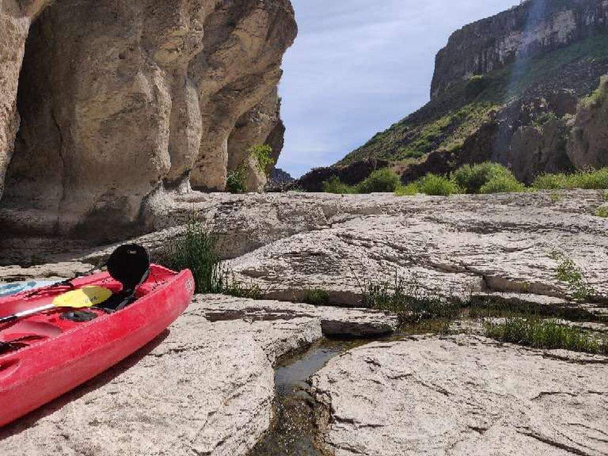 A tandem kayak sits on the rocks near the portage around Pillar Falls on August 3, 2019. Kayakers and paddleboarders can head upriver to Shoshone Falls, but they must carry their watercraft across rocks and through shallow ponds to circumnavigate Pillar Falls.