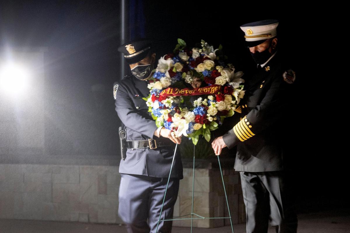 Boise Police Chief Ryan Lee and Fire Chief Mark Niemeyer carry a memorial wreath to the center of a 9/11 ceremony at the Idaho Fallen Firefighters Memorial.