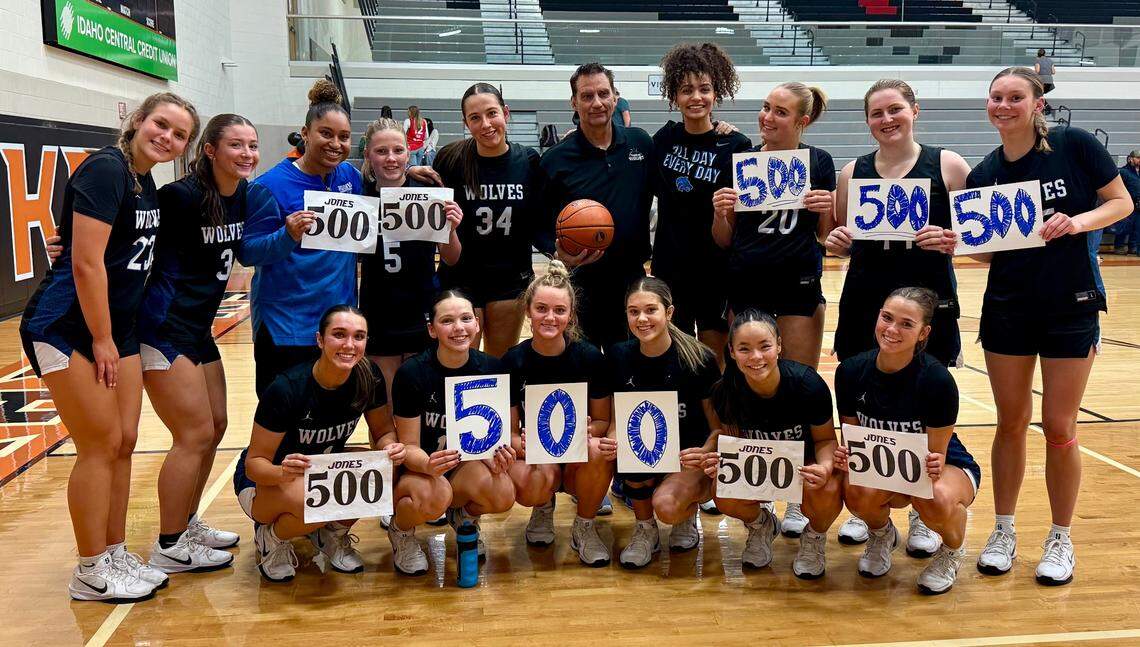 Timberline girls basketball coach Andy Jones, center with ball, poses for a photo with his team after winning his 500th career game Tuesday at Ridgevue High.