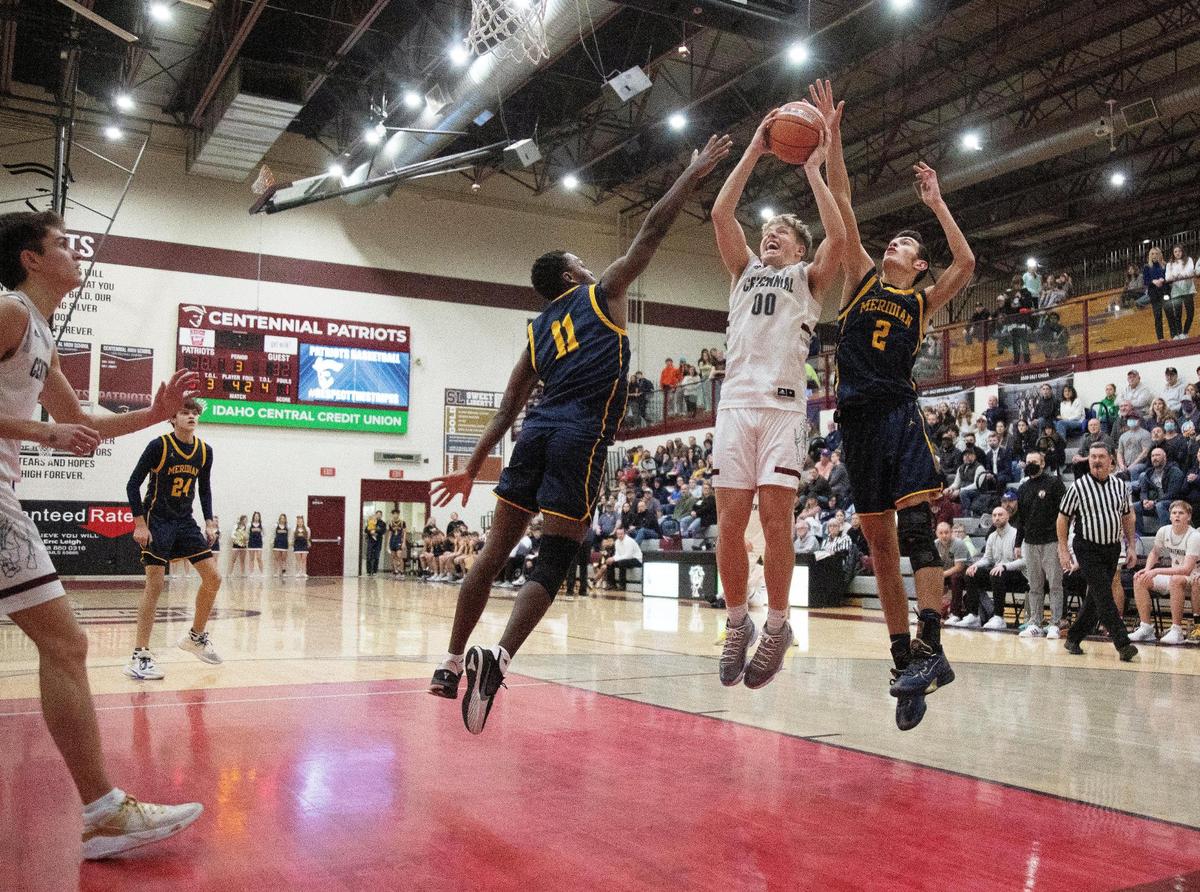 Centennial senior Will Johnson is fouled by Meridian senior Ethan Pearce, right, while Davis Thacker, left, also challenges the shot Friday.