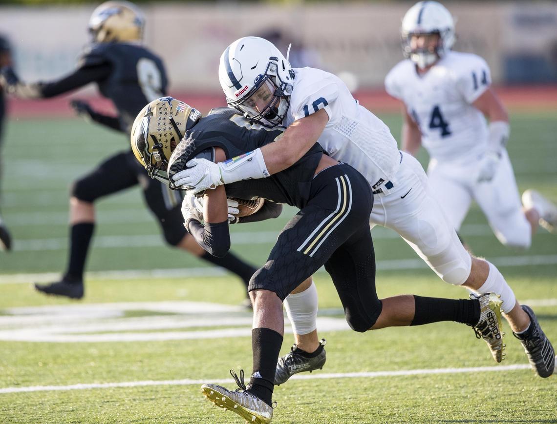 Mountain View senior Chase Norton stops Capital’s Justus Del Rio on a punt return during a Sept. 13 game at Dona Larsen Park in Boise.