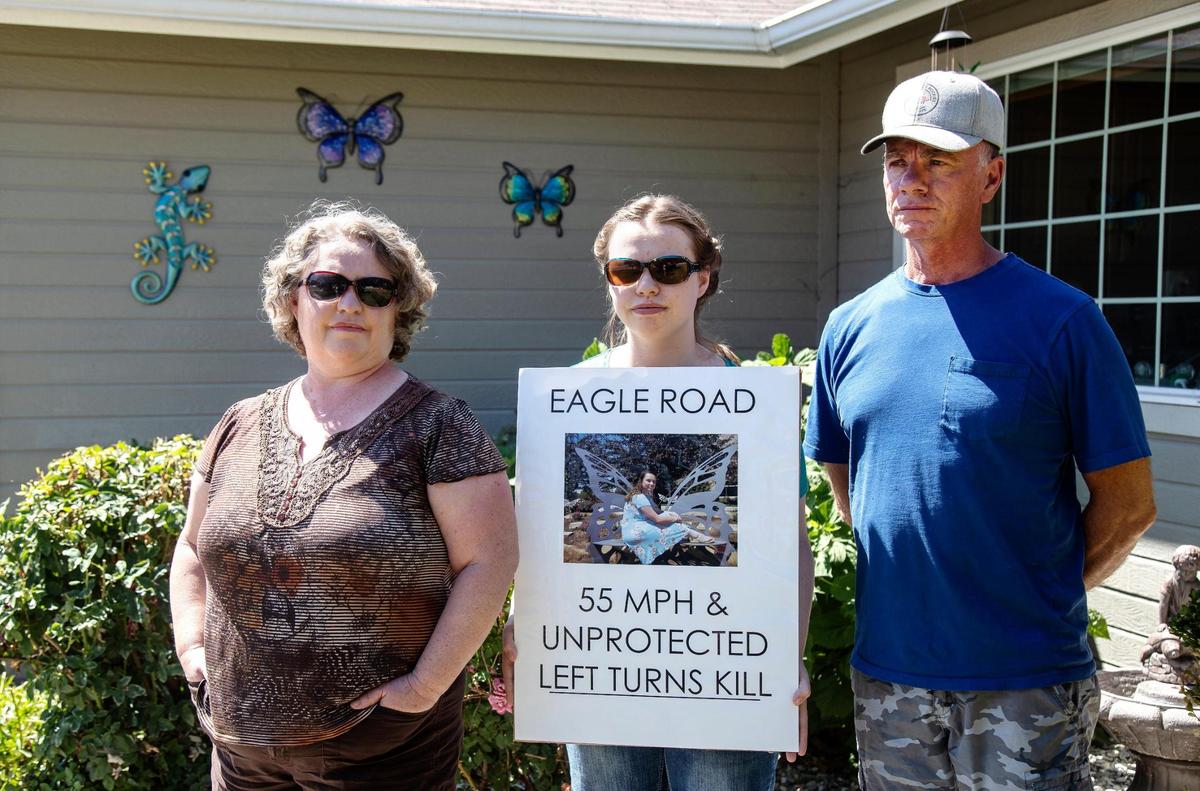 Tristen Boesch, center, holds a sign with a photo of her sister, Kess Boesch, who died in a car crash on Eagle Road in 2021. Boesch’s parents, Laurie and Jerry, have advocated for the speed limit to be lowered, and for unprotected left turns to be banned.