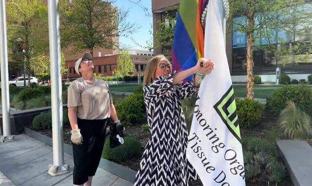 This photo, taken from a video shared with the Idaho Statesman, shows Boise Mayor Lauren McLean putting Pride and Donate Life flags back up in front of City Hall on Easter Sunday after activists covered them.