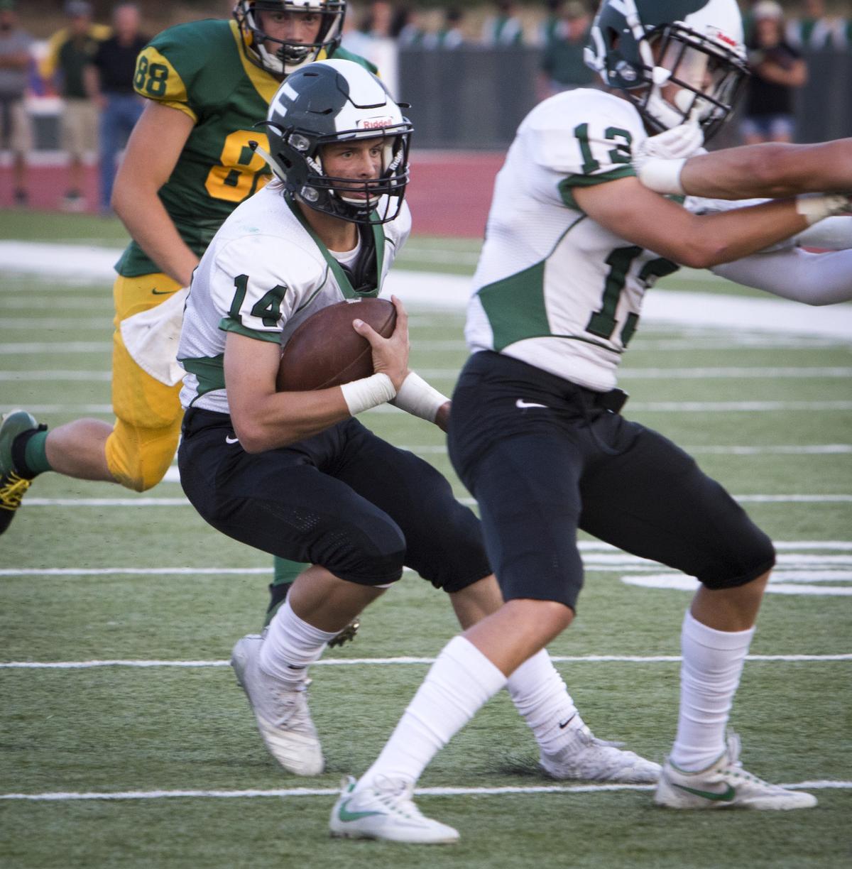 Eagle quarterback Ben Ford searches for running room against the Borah defense Thursday at Dona Larsen Park.