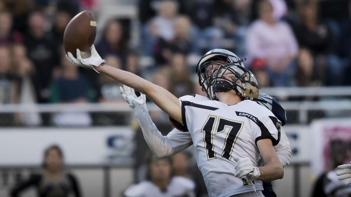 Capital wide receiver Jonah Blackham tips a pass into the air in full stride, then makes a one-hand, bobbling catch on his way to a 55-yard TD catch past Skyview defenders Wade Carpenter (1) and Brandon Crutcher (2).
