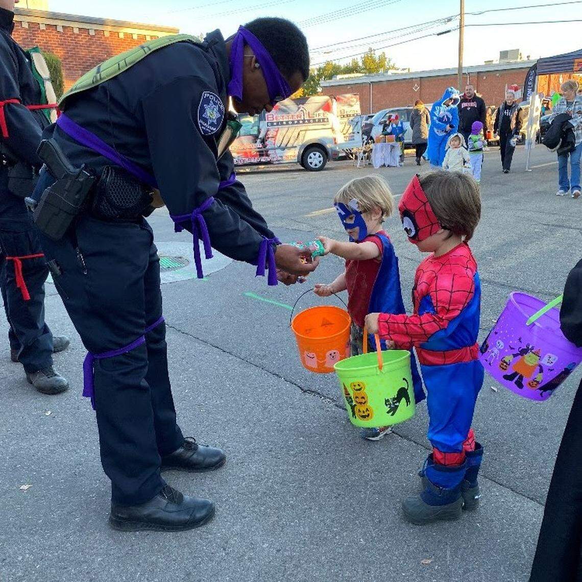 Meridian Police Officer Marquise Mangram gives Halloween candy to students at a Meridian elementary school.
