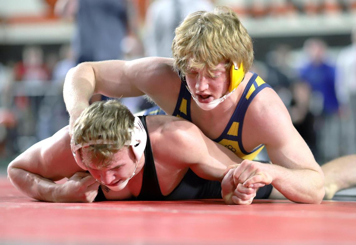 Meridian junior Isaiah Twait, top, works against Coeur d’Alene’s Gunner Giulio in the 5A 170-pound state finals at Holt Arena on Saturday in Pocatello. Giulio won the match 9-5 for his fourth state title.