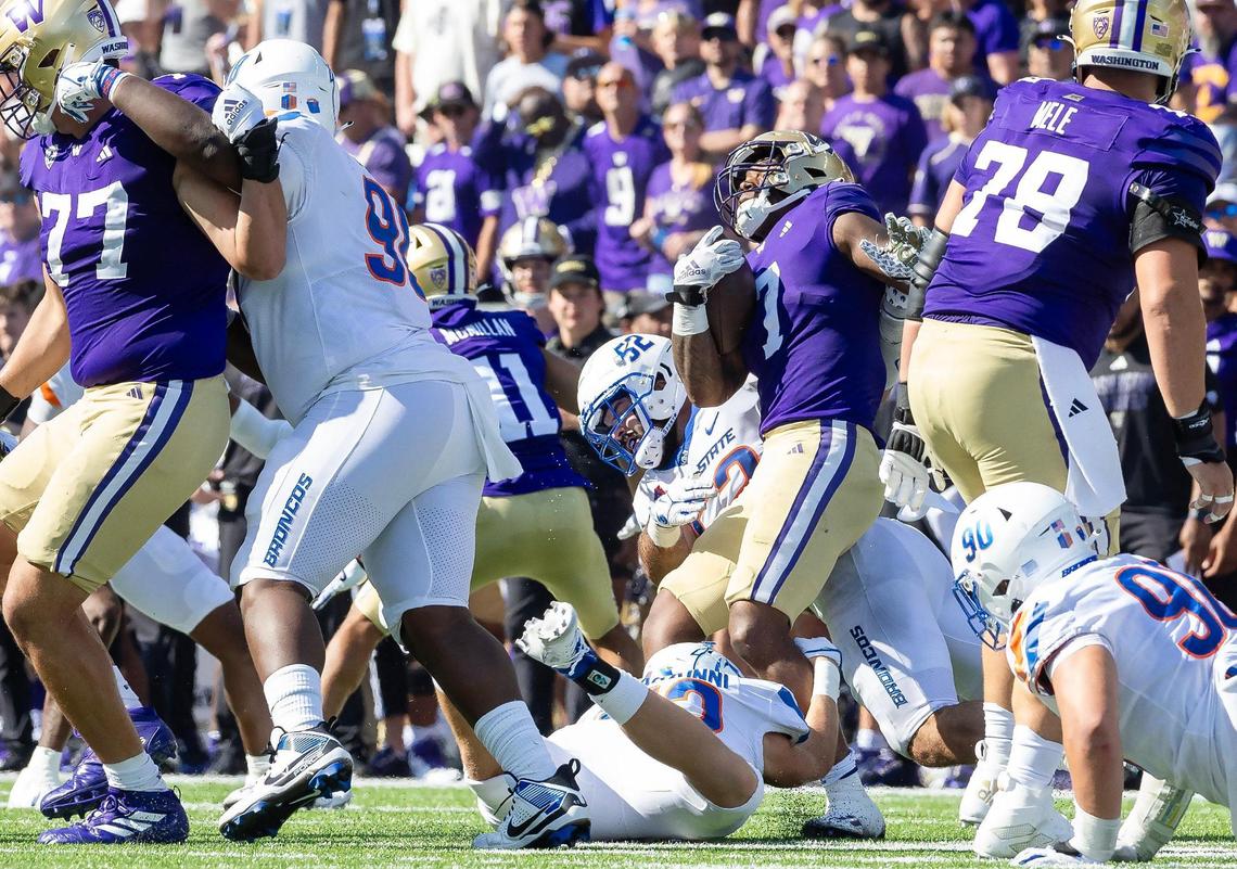 Washington running back Dillon Johnson is brought down by Boise State defenders in the fourth quarter of the Huskies’ win Saturday.