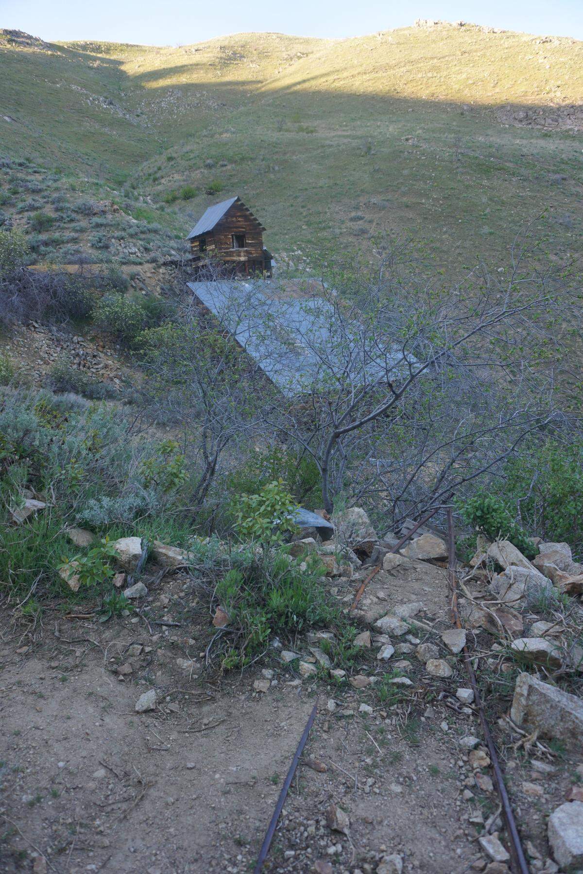 With the old mineshaft behind you, you can see rails that would’ve connected the mineshaft to the still-standing outbuilding along the Adelmann Mine trail outside Boise.