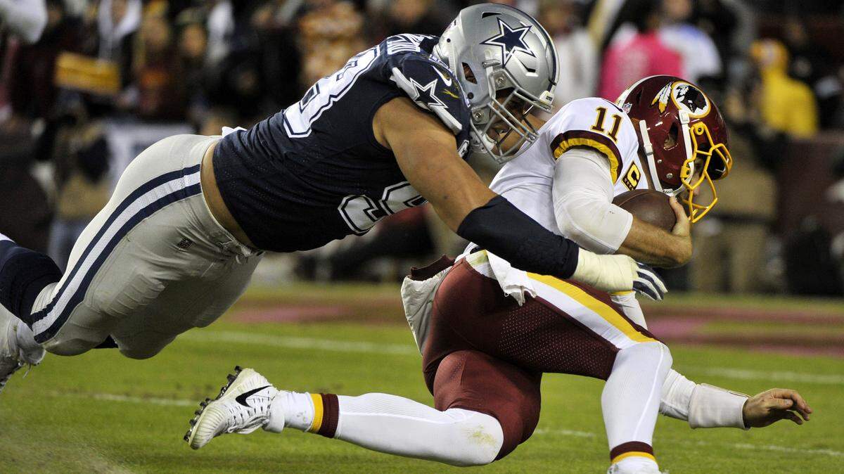 Dallas Cowboys defensive end Tyrone Crawford, left, tackles Washington Redskins quarterback Alex Smith on Oct. 21, 2018, in Landover, Md.