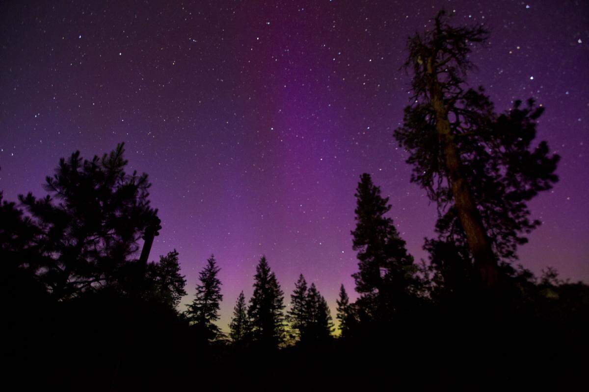 The northern lights shimmer in the night sky near Bogus Basin north of Boise, Idaho Monday June 22, 2015 just before midnight.