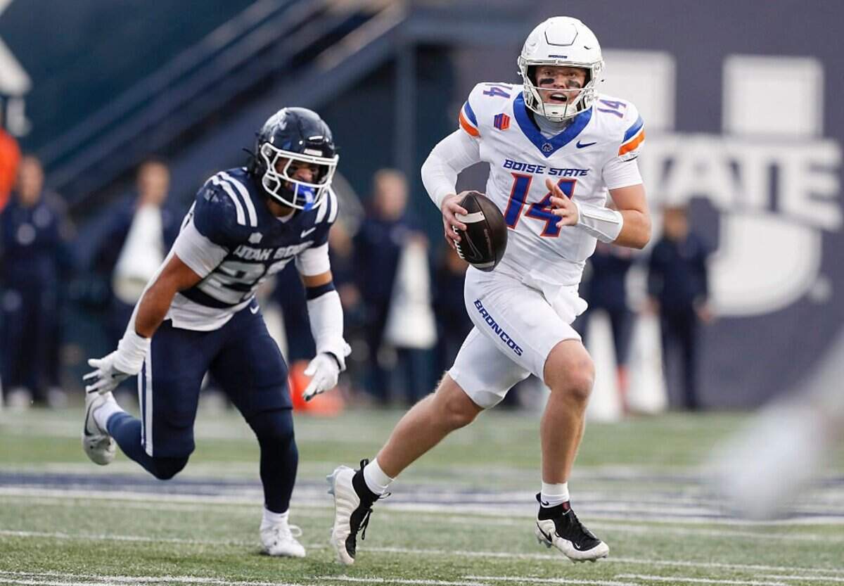 LOGAN UT - NOVEMBER 28: Max Cutforth #14 of the Boise State Broncos is chased by Chris Joe #25 of the Utah State Aggies during the first half of their game at Maverik Stadium on November 28, 2025 in Logan, Utah. (Photo by Chris Gardner/Getty Images)
