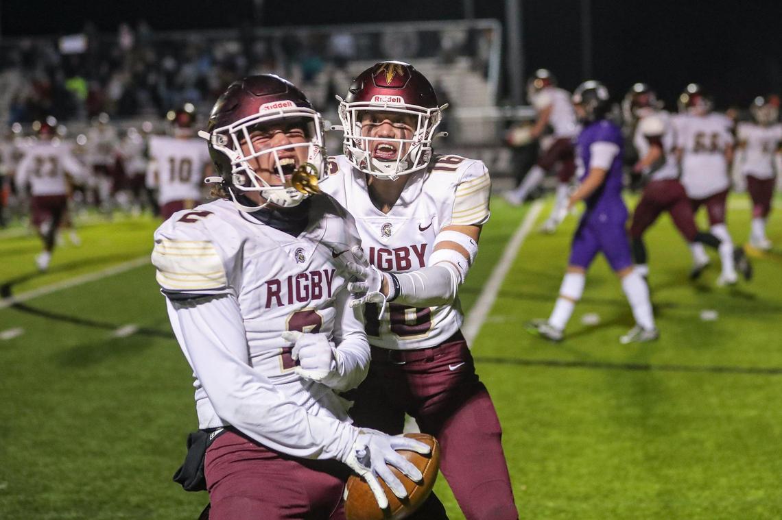 Rigby’s Jack Boudrero (2) and Parker Graham celebrate a last-minute fumble by Rocky Mountain in the 5A state semifinals Friday in Meridian. The Trojans defeated the Grizzlies 34-27.