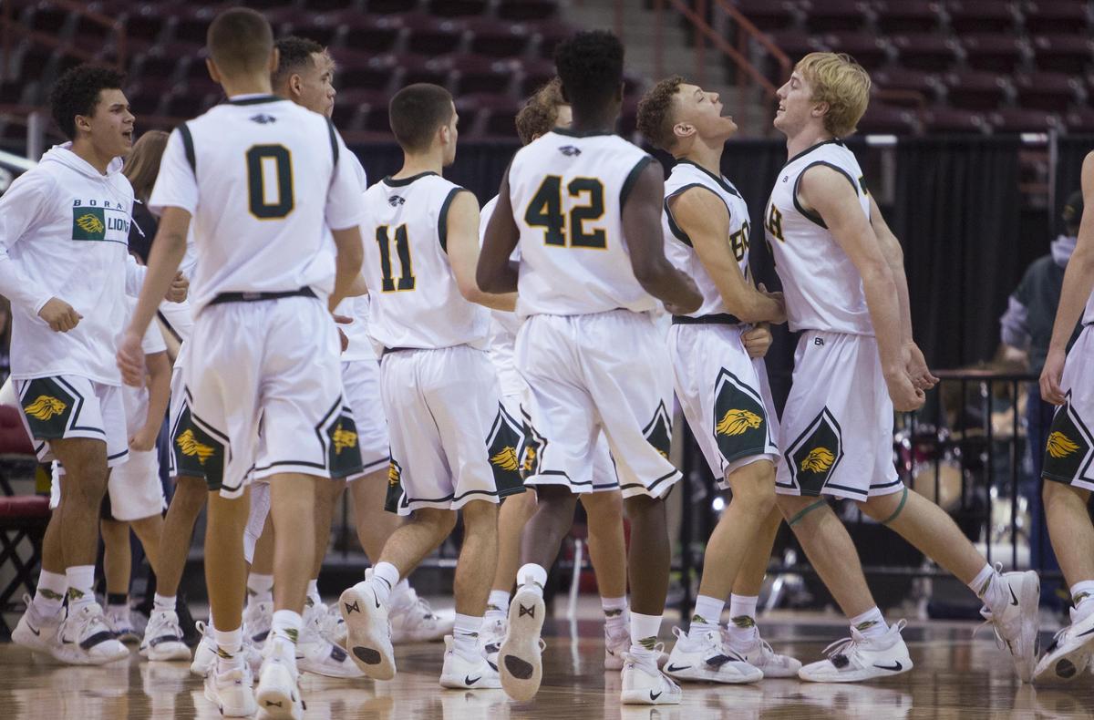 Borah junior Austin Bolt, right, celebrates with teammates after sinking a shot at the end of the first quarter against Rigby.