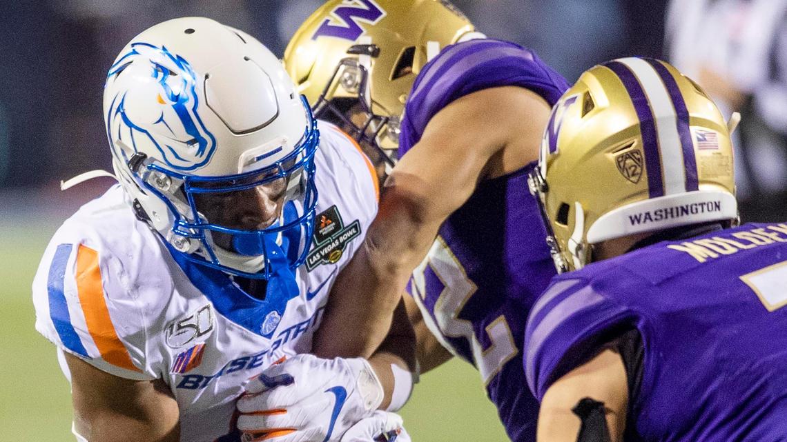 Boise State quarterback Jaylon Henderson holds onto the football as Washington defensive back Trent McDuffie tries to strip it in the third quarter of the Las Vegas Bowl.