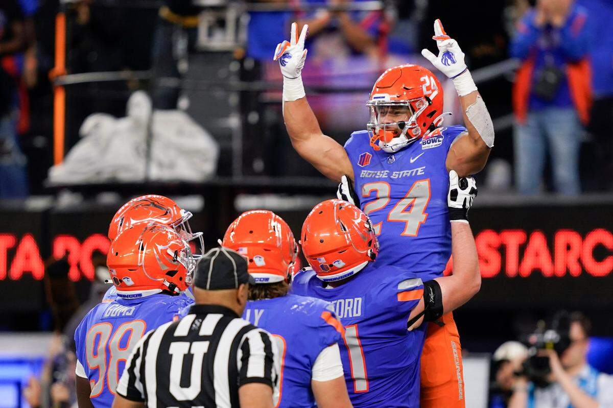 Boise State running back George Holani (24) is lifted by offensive lineman Cade Beresford after scoring a touchdown in the first half of the Broncos’ 35-22 loss to UCLA in the LA Bowl on Saturday.