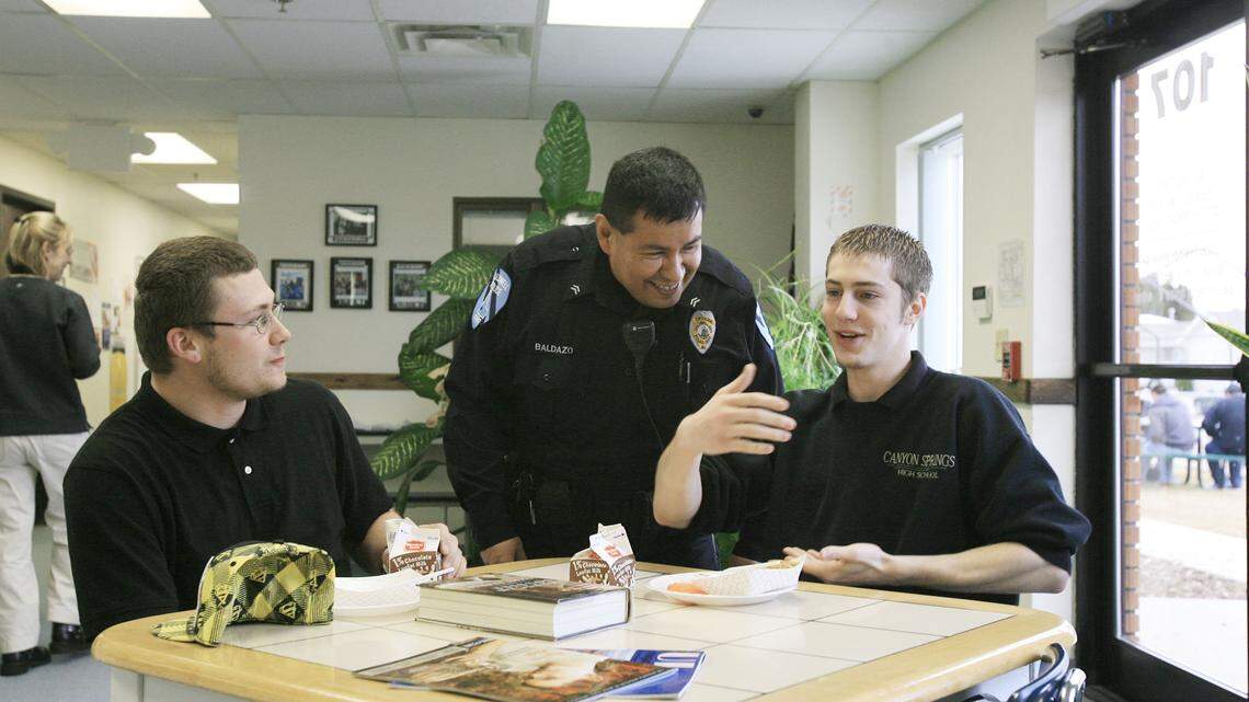 In this file photo from 2010, Caldwell Officer John Baldazo, a school resource officer, jokes with seniors during lunch at Canyon Springs High. The Caldwell School District board voted to approve a contract with a private security company in lieu of school resource officers.