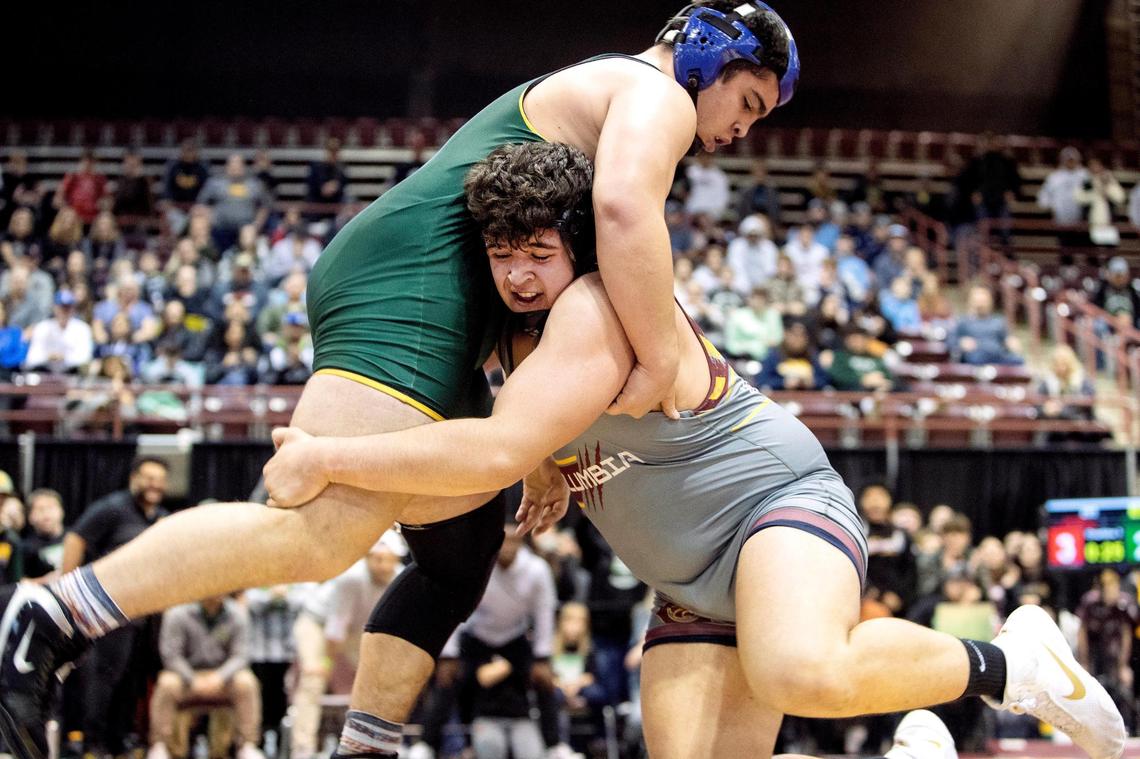 Columbia’s Nico Rodriguez, right, lifts Borah’s Aden Attao off the mat during the heavyweight finals at the Rollie Lane Invite in January.