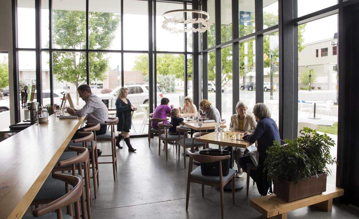 The dining area at Txikiteo features two walls of roof-to-floor window light befitting a modern, sleek interior.