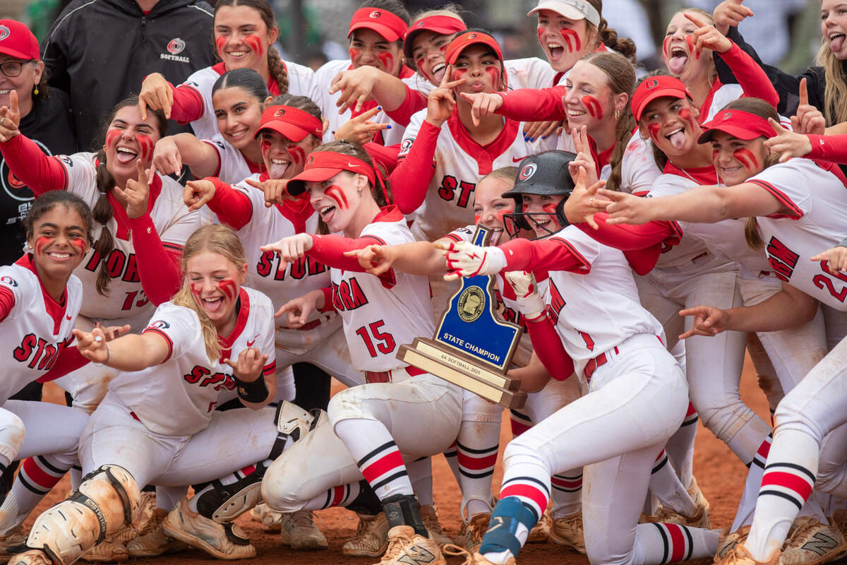 Owyhee’s softball team celebrates with the 6A state championship trophy Saturday at Eagle High School.