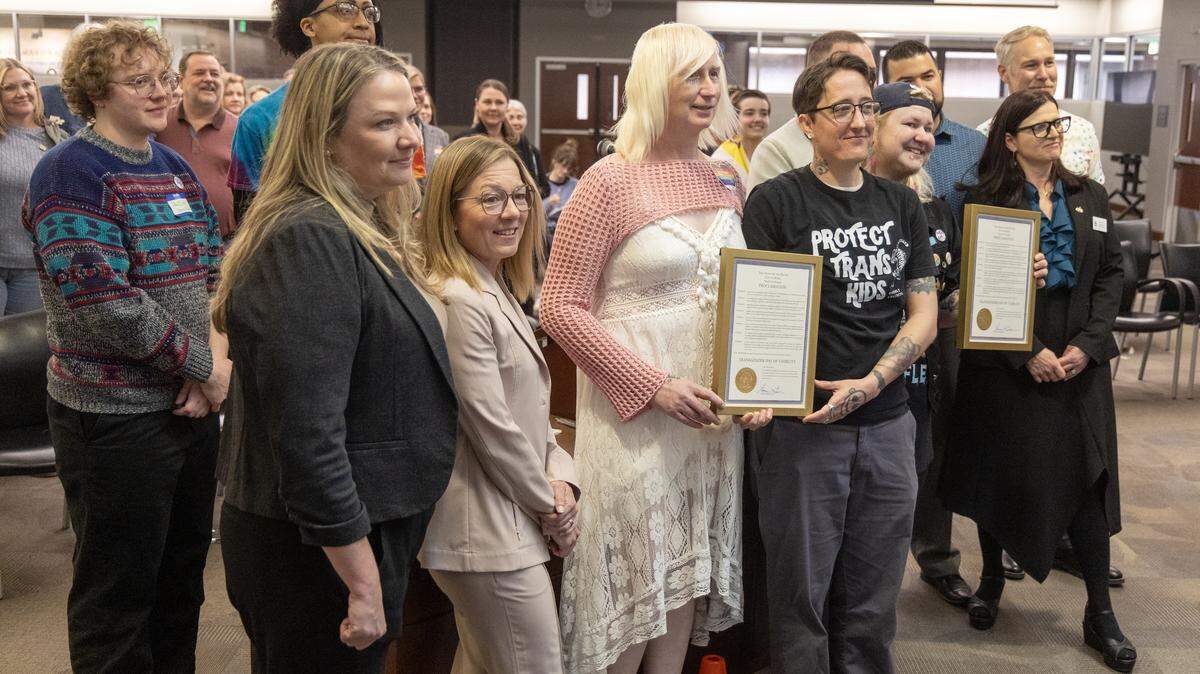 Boise City Council members and Mayor Lauren McLean pose with the leaders of organizations that support transgender rights. Preston Pace, on the right in a black shirt that says ”Protect trans kids,” thanked the city for helping the transgender community in Boise feel safe. Pace is cofounder of Trans Joy Boise, a transgender advocacy group.