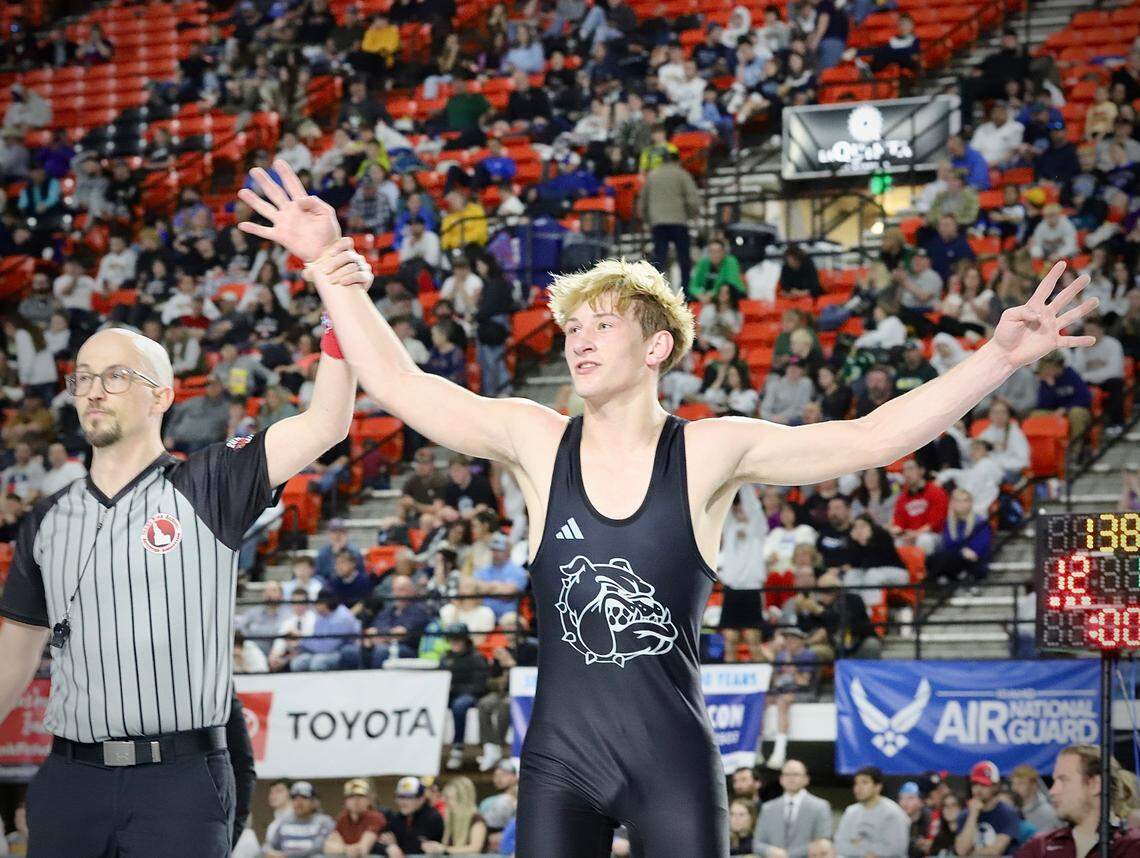 Nampa senior Carson Exferd puts four fingers in the air Saturday after winning his fourth consecutive state championship at the ICCU Dome in Pocatello.