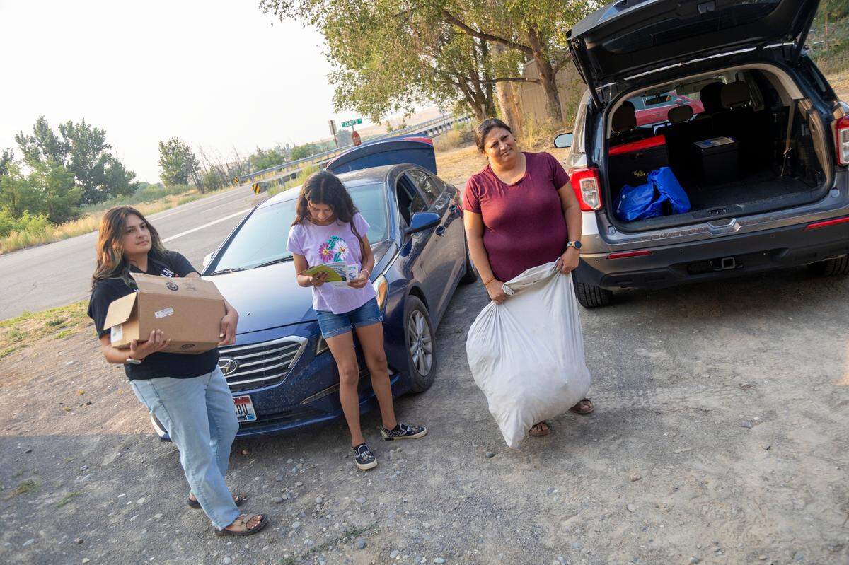 Alejandra Hernandez, from left, along with AnaMaria Morales and Arcadia Hernandez, deliver clothes and hot-weather supplies to agricultural workers in Hammett.
