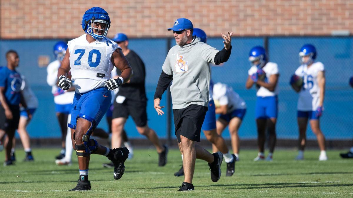 Boise State offensive lineman John Ojukwu begins the first day of fall camp with warmups along side Coach Tim Kenne, Wednesday, Aug. 3, 2022.
