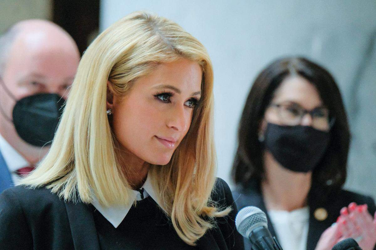 Paris Hilton, who has spoken out about the abuses she said she experienced at Provo Canyon School, center, stands with Utah Gov. Spencer Cox and Lt. Gov. Deidre Henderson at the Utah Capitol rotunda in April. Hilton advocated for a family whose son was in Idaho Child and Family Services custody for nearly 8 months.