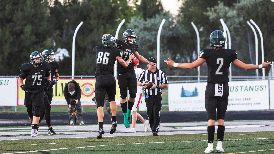 Eagle quarterback Jake Longson celebrates a touchdown with tight end Cal Huish on Friday.