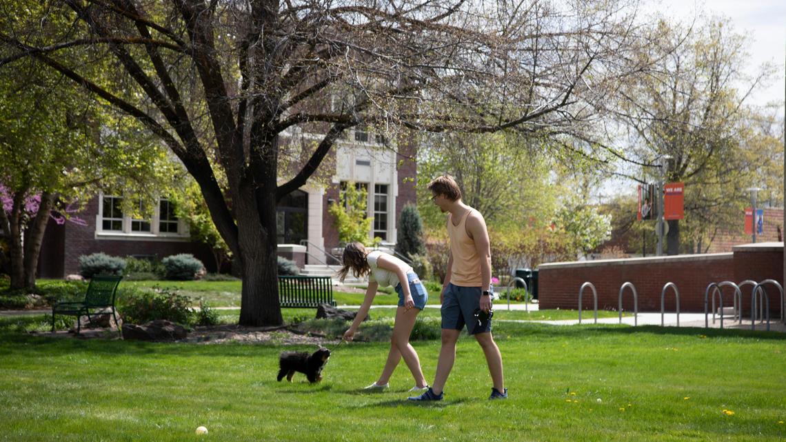 Emily Wetherwax and Justin Lobaugh play with Archie, their roommate’s dog, in the deserted Boise State University campus on April 22 amid the coronavirus pandemic. Wetherwax, an art history major, was on a quick break between Zoom classes.