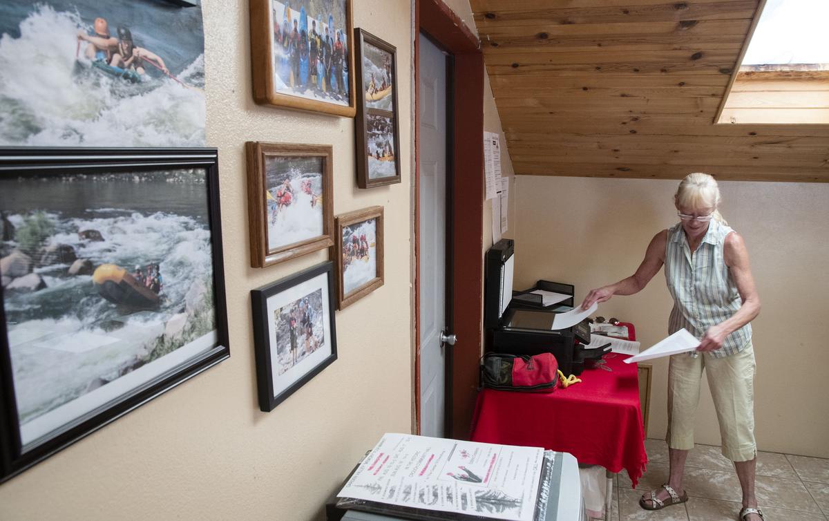 Photos of happy clients line the walls of Idaho Whitewater Unlimited Inc., as Georgianna Lawler makes copies of paperwork from a debacle that ensued when Craig Fletcher tried to buy the business a few years ago. She and husband John “JB” Lawler have worked to get Idaho Whitewater Unlimited back on its feet after thinking they had sold it.