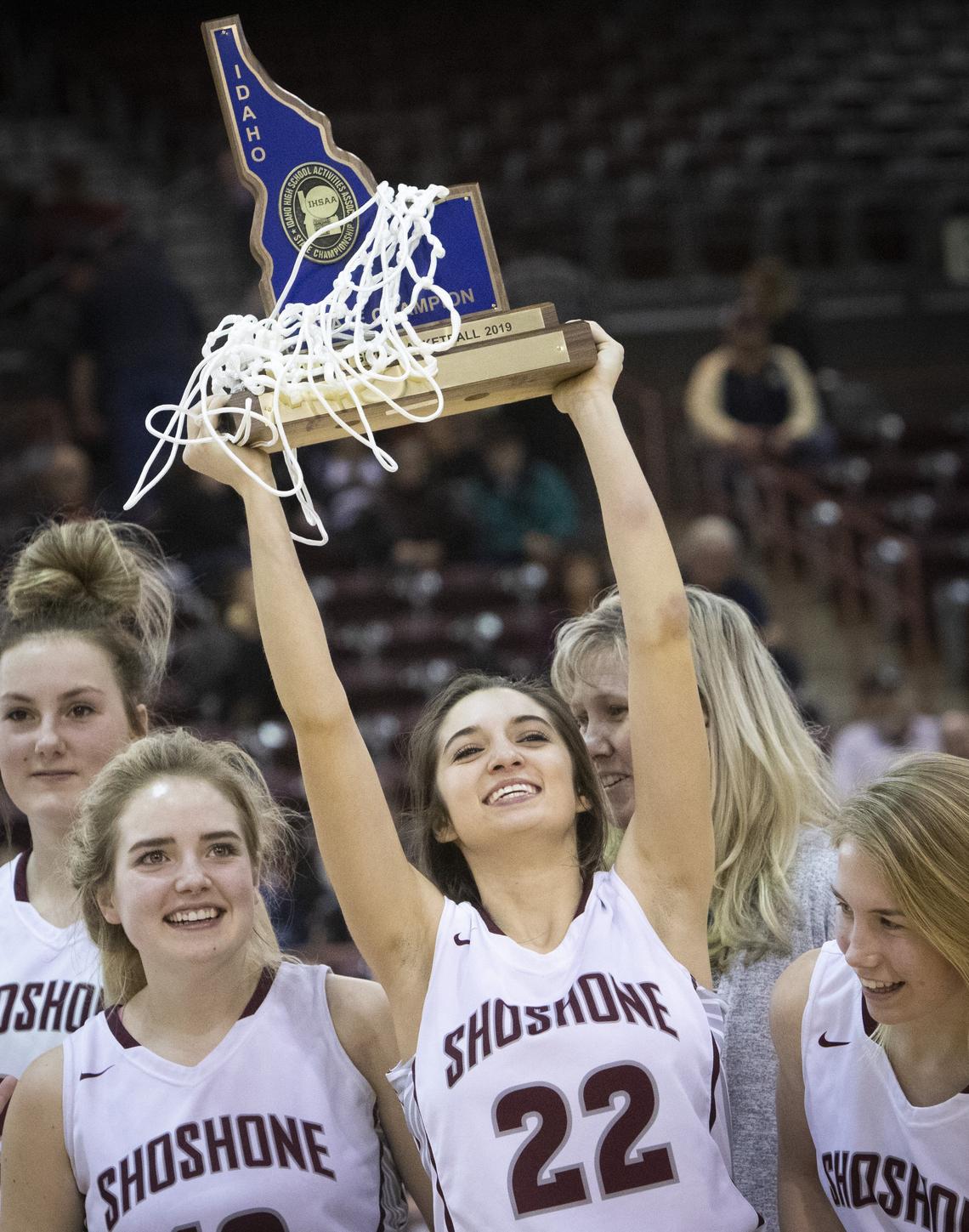 Senior Cierra Hennings raises the Shoshone trophy triumphantly after their win over Genesee to take first place in the 1A Div. I state girls basketball championship at the Idaho Center on Saturday, Feb. 16, 2019.