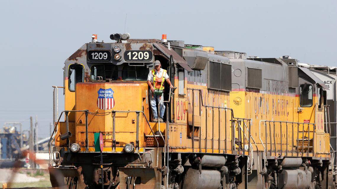 FILE - In this July 20, 2017, file photo, a Union Pacific Railroad Company employee stands on a locomotive in this file photo. (AP Photo/Nati Harnik, File)