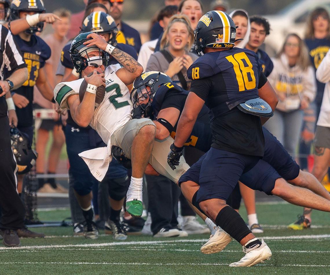 Meridian linebacker Jackson Seaver decleats Eagle quarterback Austin Ramsey in their season-opening game last year in Homedale. 