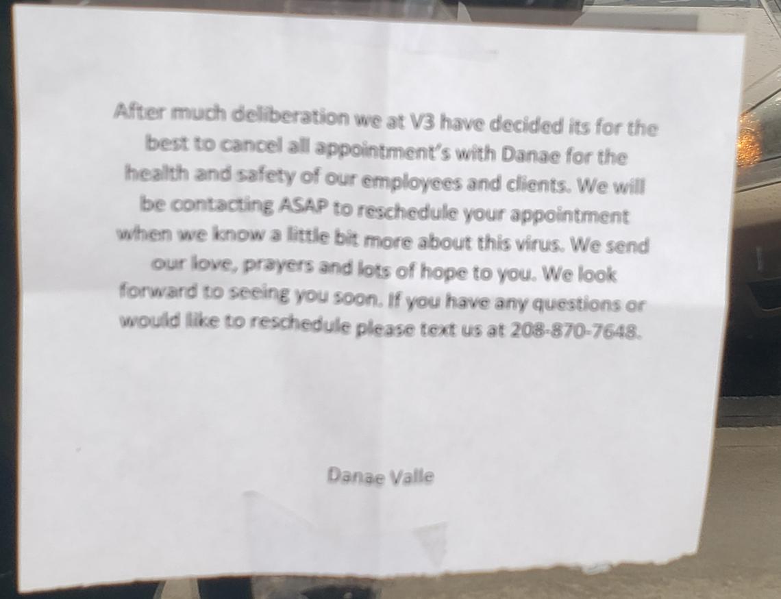 A sign on the door of V3 Hair Studio asks customers whose appointments were canceled as a result of the coronavirus pandemic to text or call to schedule new ones.