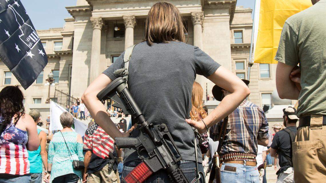 A woman totes an AR-15 at a 2018 rally in Idaho.