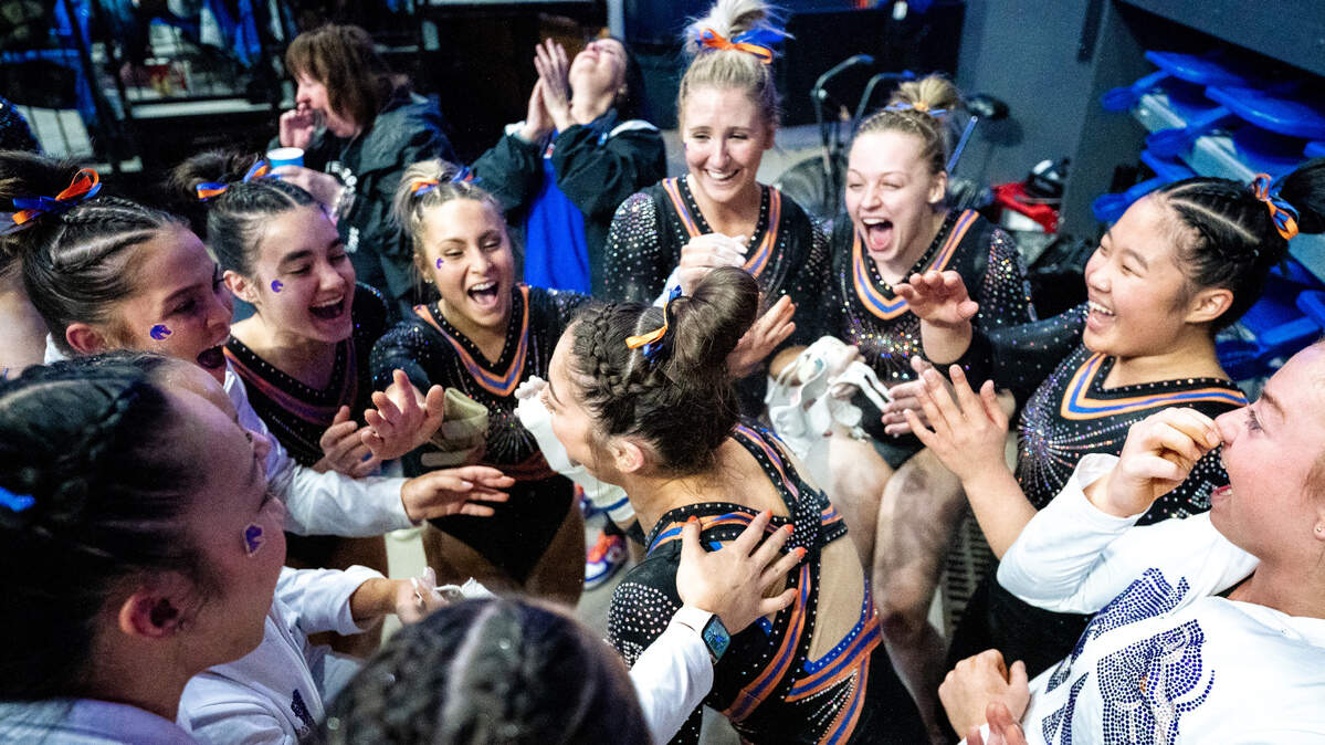 Boise State gymnast Emily Lopez is swarmed by teammates after her perfect score in bars was announced during a meet against BYU on Feb. 17.