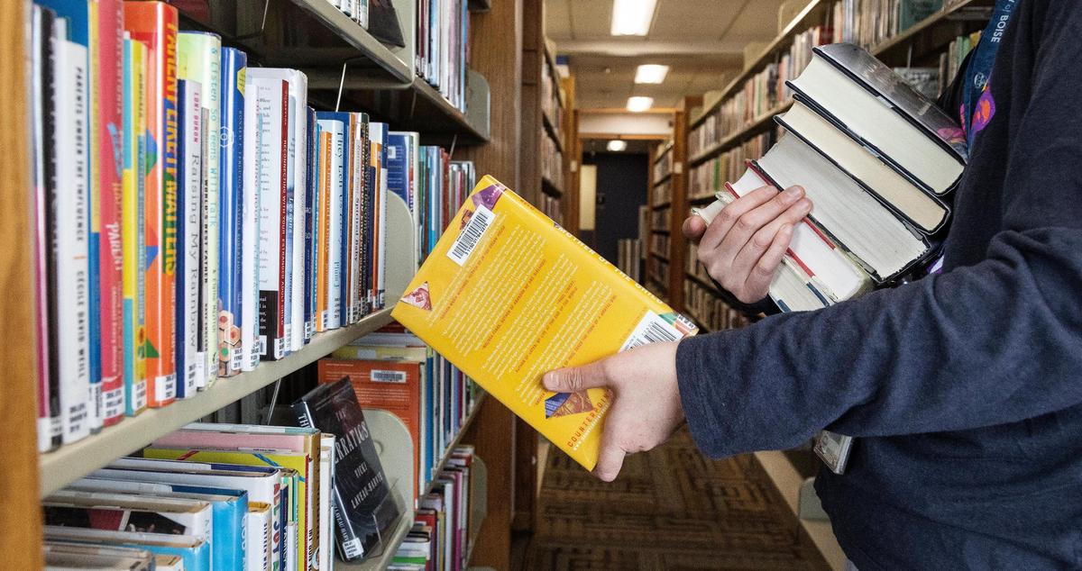 A librarian returns books to the shelves at the Boise Public Library. The library system is working to combat COVID learning loss by meeting kids where they are this summer.